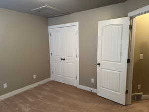 Unfurnished bedroom with light colored carpet and a closet