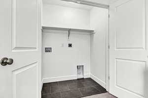 Laundry area featuring hookup for a washing machine, dark tile patterned flooring, and hookup for an electric dryer