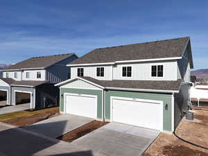 View of front of house with a mountain view, a garage, and central AC unit