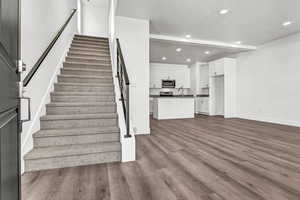 Stairs featuring sink, wood-type flooring, and a textured ceiling