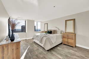 Owner's suite bedroom with large windows featuring stunning city, mountain, valley views.