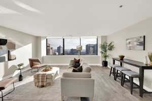 Living room with large windows opening up to gorgeous views of Salt Lake City, mountains, valley.