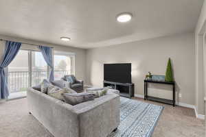 Living room featuring a textured ceiling and light colored carpet