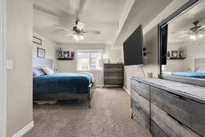 Carpeted bedroom with a textured ceiling and ceiling fan