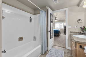 Bathroom featuring ceiling fan, shower / bath combo with shower curtain, and vanity