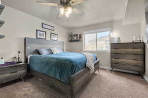 Carpeted bedroom featuring ceiling fan