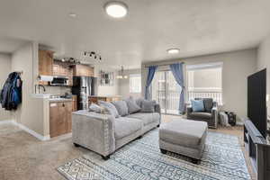 Living room featuring light carpet, a textured ceiling, and an inviting chandelier