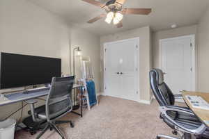 Office with ceiling fan and light colored carpet