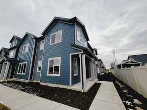 View of property exterior with front door and front porch facing west