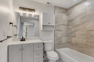 Full bathroom featuring vanity, toilet, and tiled shower / bath