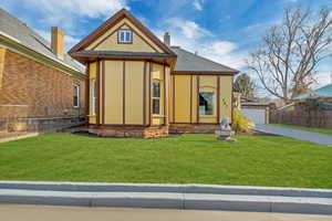 View of front of property with a garage and a front lawn