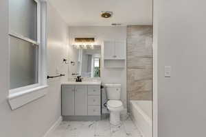 Full bathroom with shower / bathing tub combination, vanity, and toilet