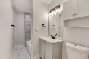 Full bathroom featuring vanity, toilet, and tiled shower / bath