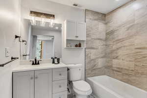 Full bathroom featuring vanity, toilet, and tiled shower / bath combo