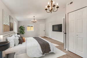 Bedroom with carpet flooring, a closet, a chandelier, and lofted ceiling