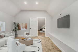 Living room featuring light colored carpet and lofted ceiling