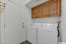 Laundry area with separate washer and dryer and cabinets