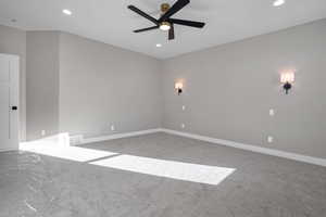 Carpeted spare room featuring ceiling fan