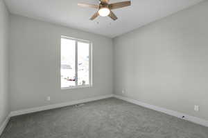 Carpeted empty room with ceiling fan