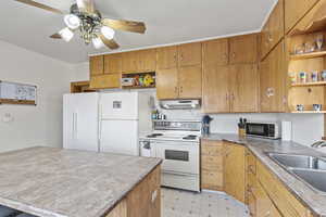 Kitchen featuring ceiling fan, sink, and white appliances