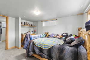 Bedroom featuring light carpet and a textured ceiling