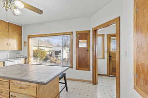 Kitchen with tile counters, ceiling fan, and dishwasher