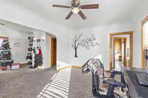 Office space with carpet flooring, ceiling fan, and a textured ceiling