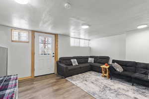 Living room with a textured ceiling and hardwood / wood-style flooring