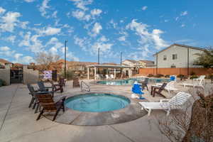 View of pool featuring a hot tub and a patio area