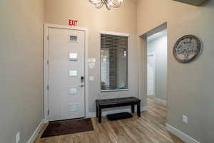 Foyer with an inviting chandelier and light wood-type flooring