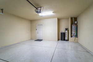 Garage featuring secured water heater and a garage door opener