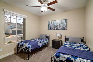 Carpeted bedroom featuring ceiling fan