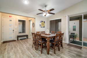 Dining space with ceiling fan, lofted ceiling, and light wood-type flooring