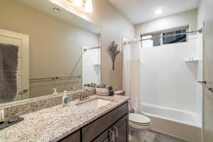 Full bathroom with tile patterned flooring, vanity, toilet, and shower / bathtub combination with curtain