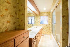 Bathroom with vanity and enclosed tub / shower combo