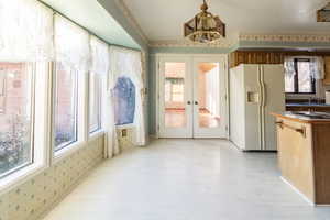 Interior space with an inviting chandelier, sink, and french doors