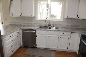 Kitchen with sink, white cabinetry, and stainless steel appliances