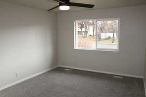 Carpeted empty room with ceiling fan