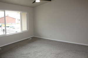 Unfurnished room featuring carpet flooring and ceiling fan