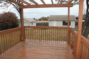 Deck featuring a yard, a pergola, and an outdoor structure