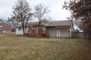 Back of property featuring a deck and a lawn