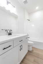 Full bathroom featuring bathtub / shower combination, wood-type flooring, toilet, and vanity