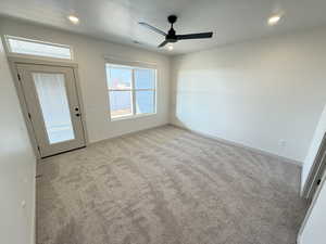 Carpeted empty room featuring ceiling fan