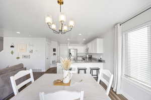 Dining space with dark hardwood / wood-style flooring and a notable chandelier