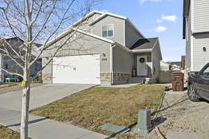 View of front of home with a garage and a front lawn