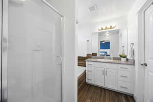 Primary Bathroom featuring wood style tile floors, with a separate shower and tub, and walk-in closet