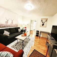 Living room with a textured ceiling and hardwood / wood-style flooring