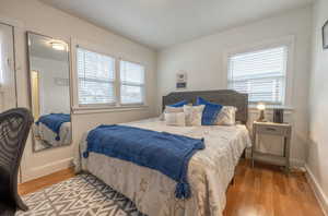 Bedroom with light hardwood / wood-style flooring and multiple windows