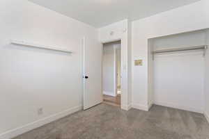 Unfurnished bedroom with carpet flooring and a closet