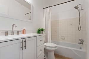 Full bathroom featuring hardwood / wood-style flooring, vanity, toilet, and shower / bath combo